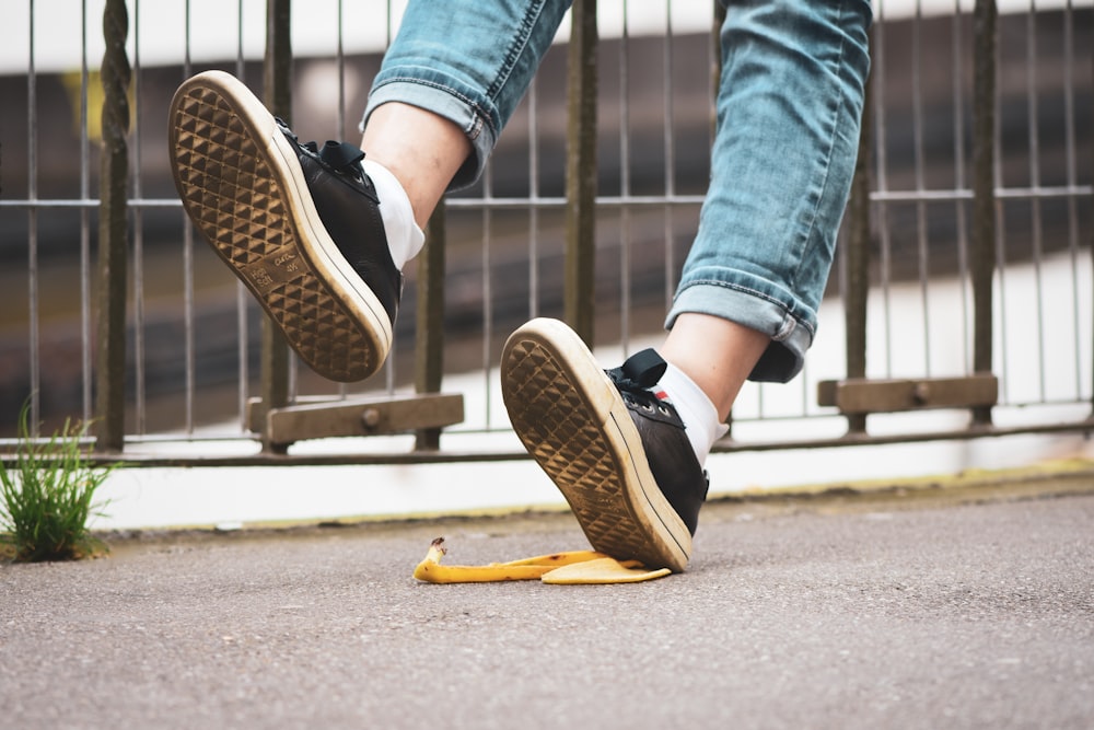 eine Person, die auf eine Bananenschale auf dem Boden tritt