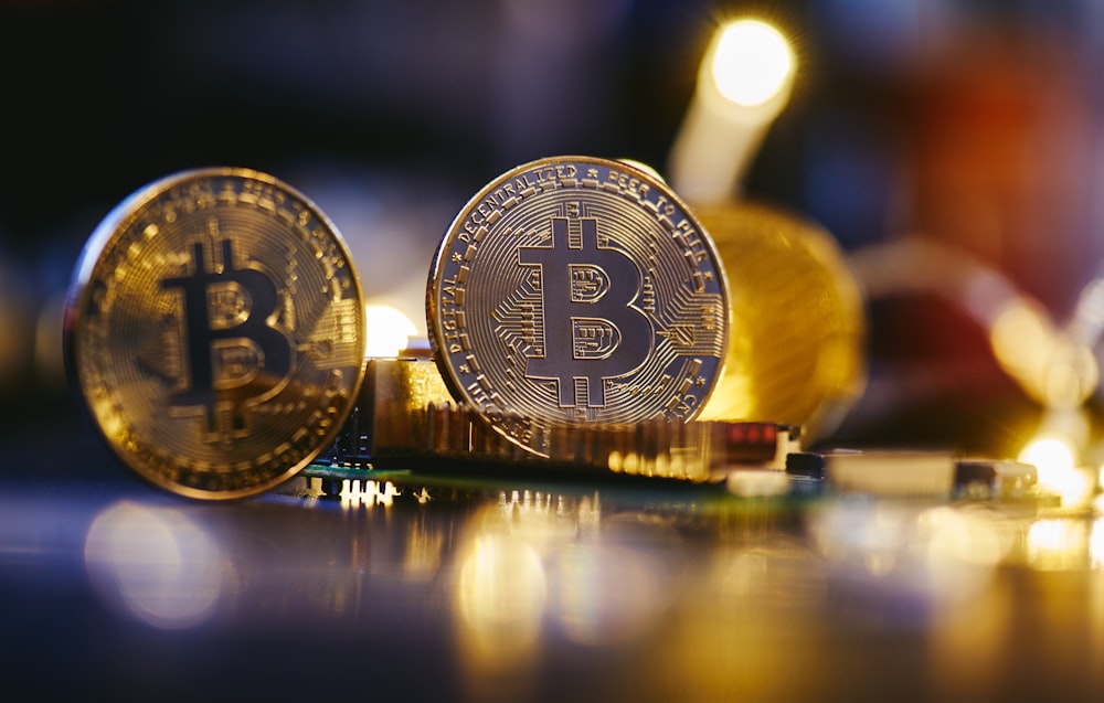 Dos bitcoins sentados uno encima del otro en una mesa