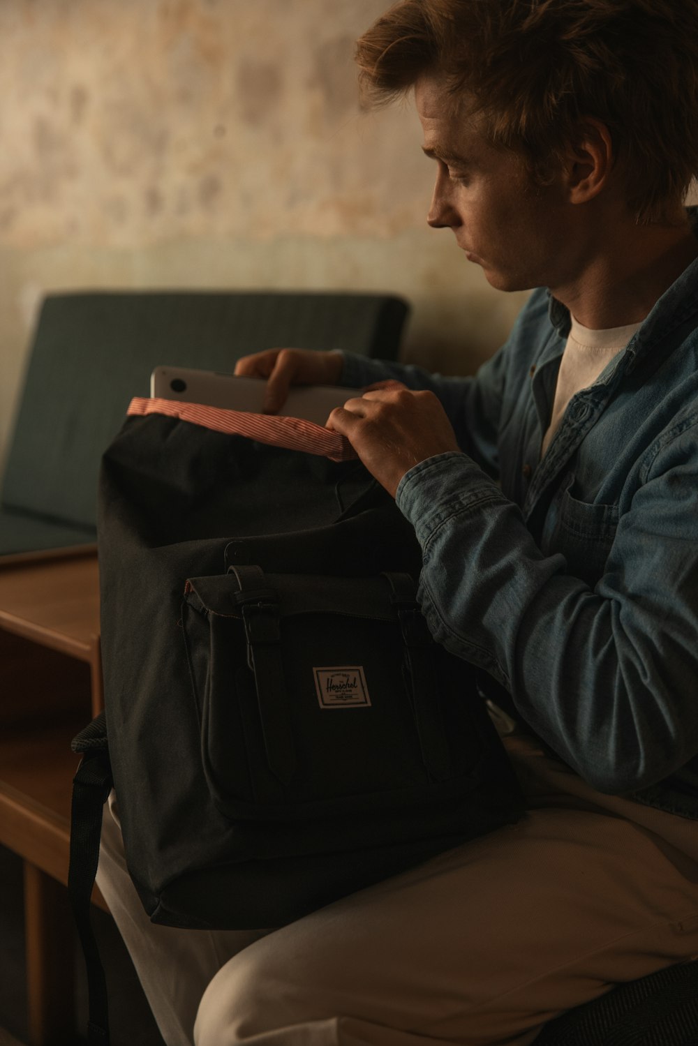 Ein Mann sitzt mit einem Rucksack auf dem Schoß