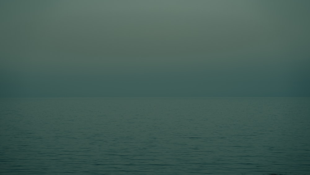 a large body of water sitting under a cloudy sky