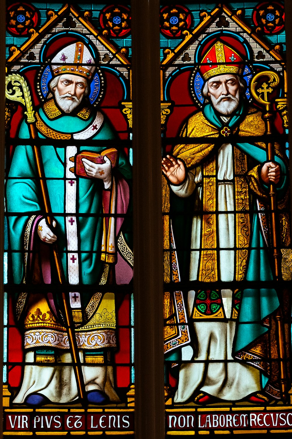 a stained glass window with a man holding a cross