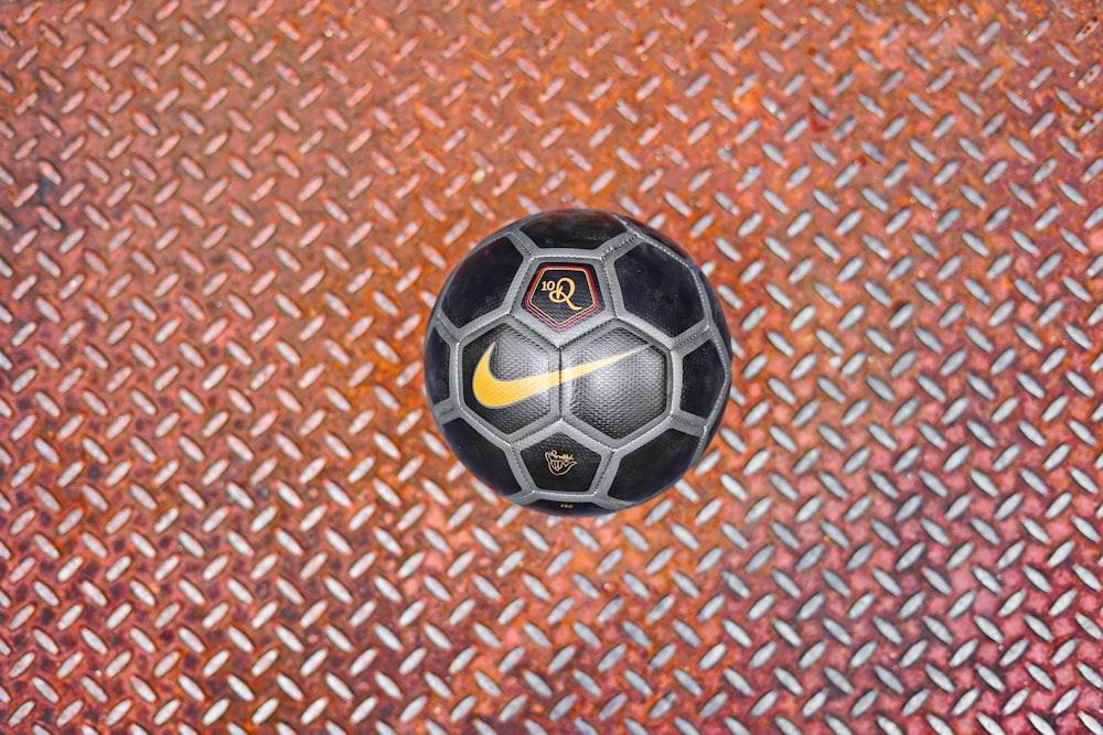 un ballon de soccer posé sur un sol métallique