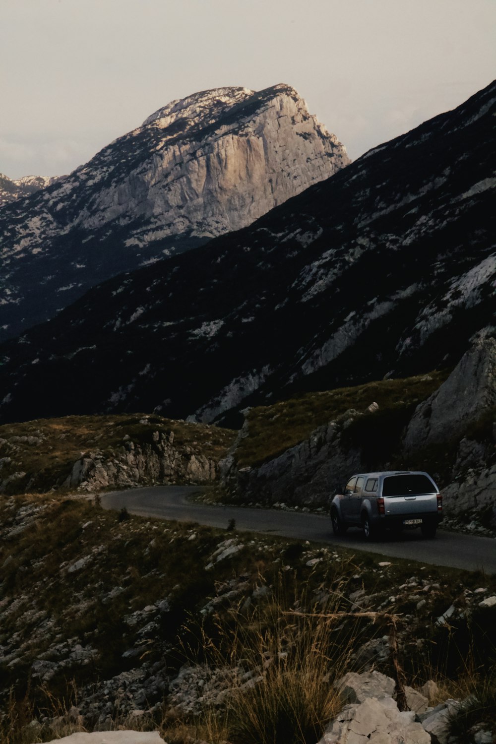 Un'auto che guida lungo una strada in montagna