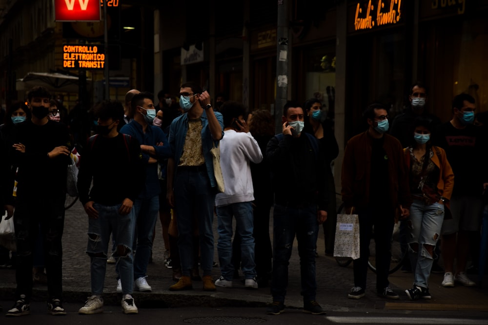 a group of people standing on a street corner