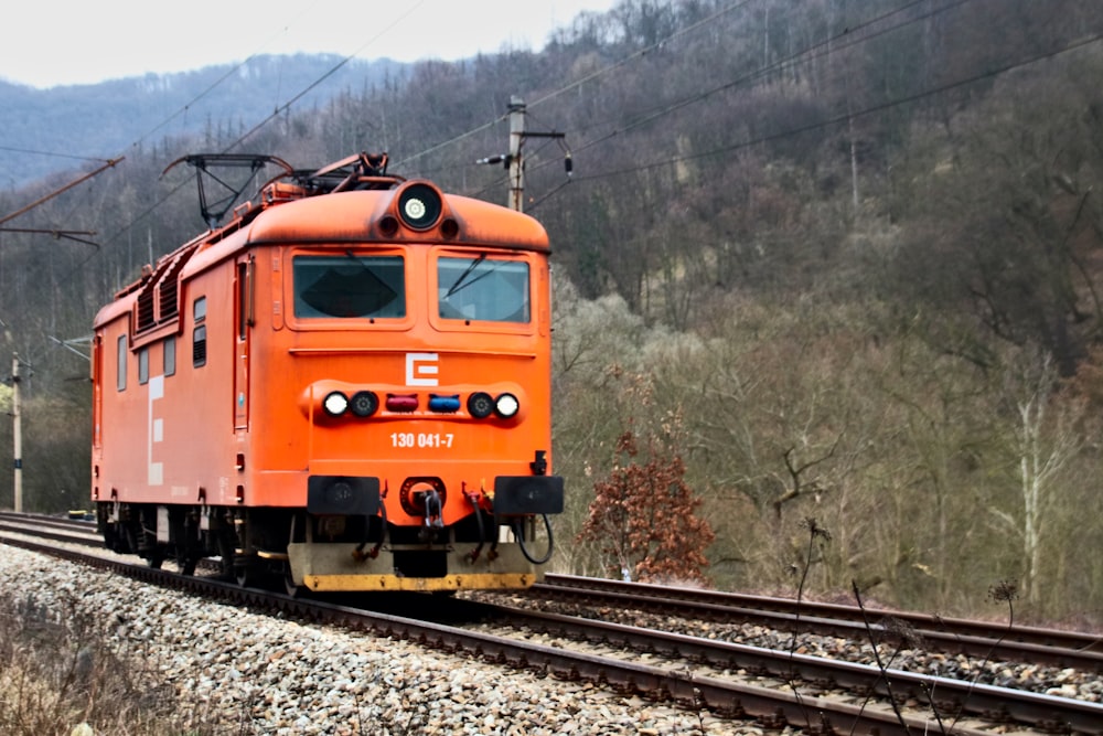 orange and black train on rail tracks