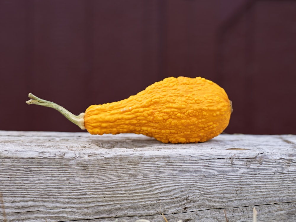 a yellow gourd sitting on top of a wooden table