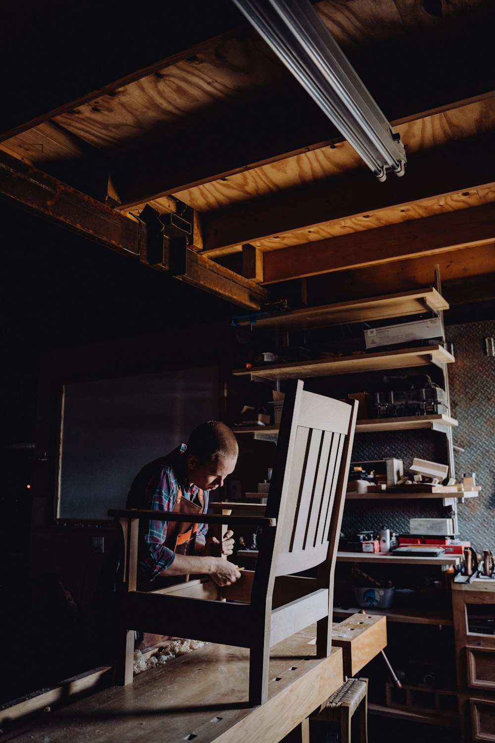 a man working on a chair in a workshop