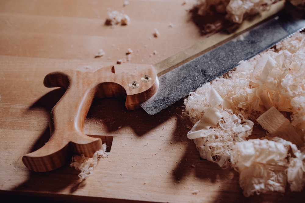 a knife and some wood shavings on a table