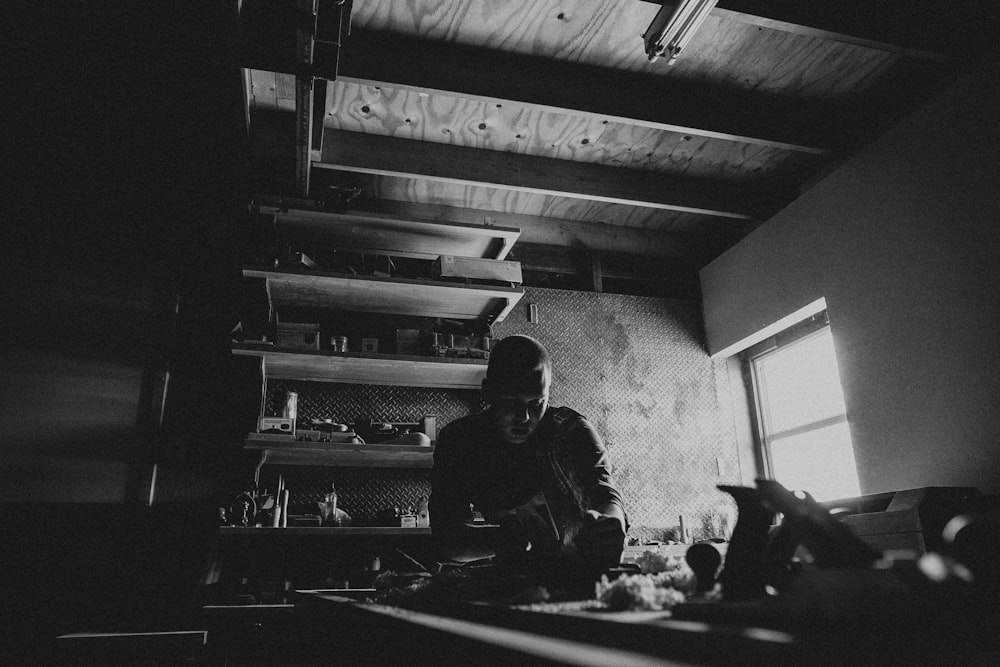 a black and white photo of a person in a kitchen