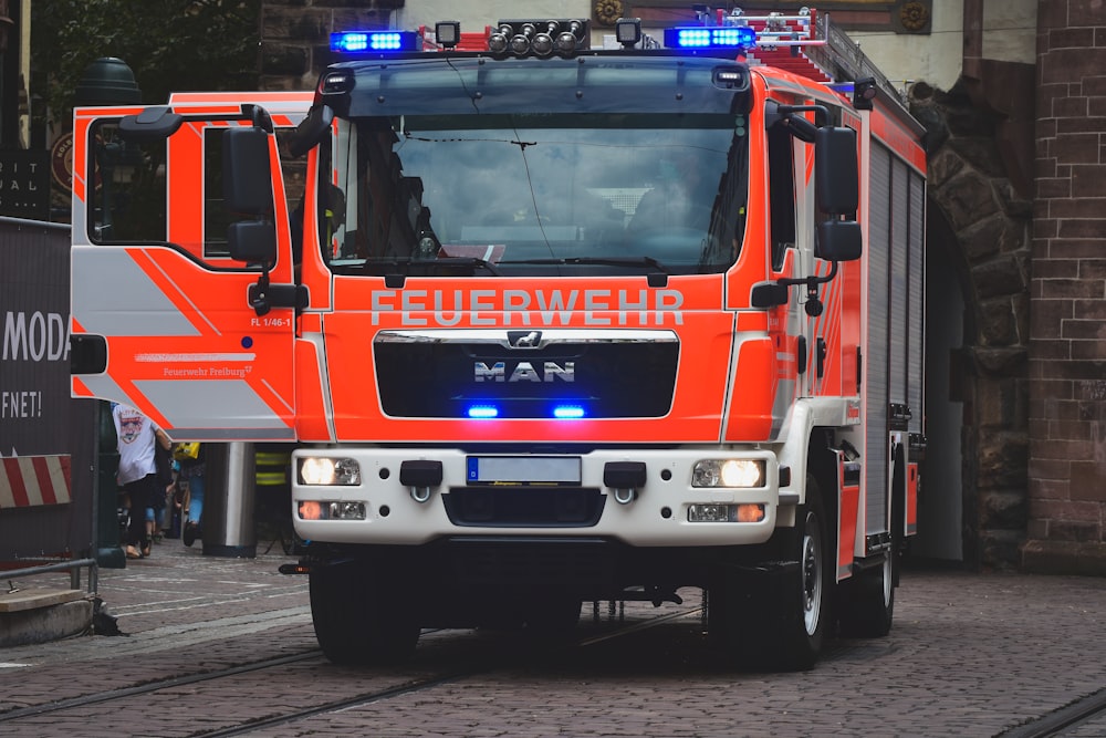 an orange fire truck driving down a street