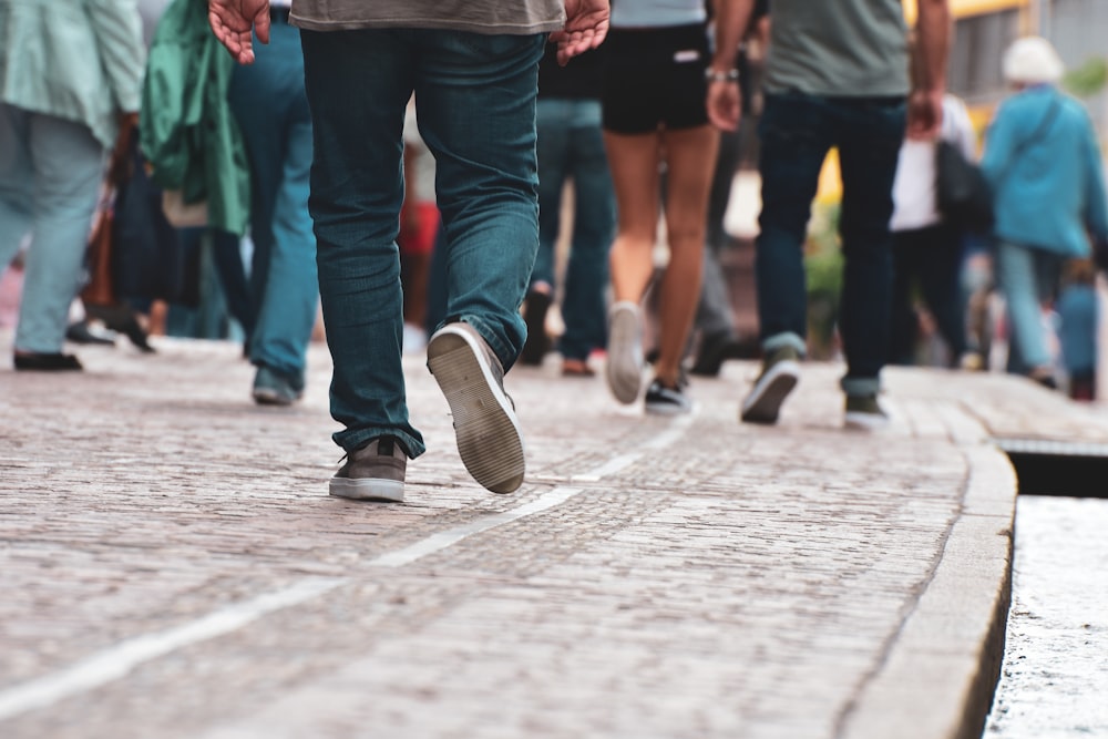 a group of people walking down a sidewalk