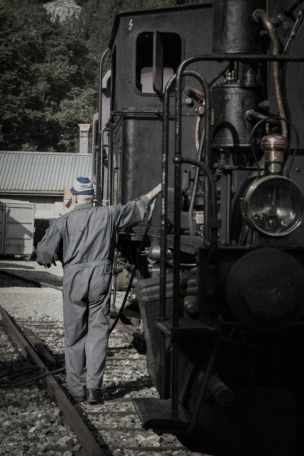 a man standing next to a train on a train track