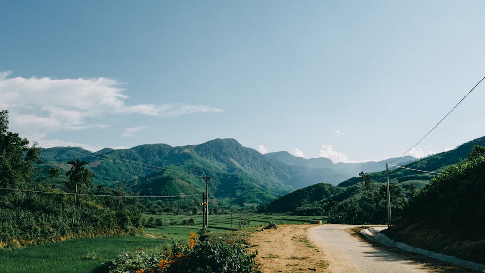 a dirt road surrounded by lush green mountains