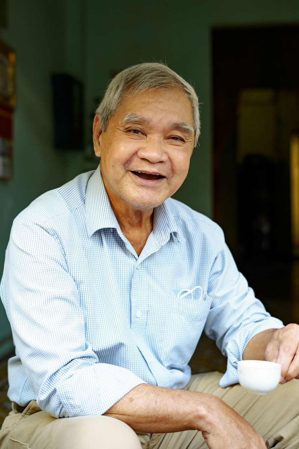 a man sitting on a couch holding a cup