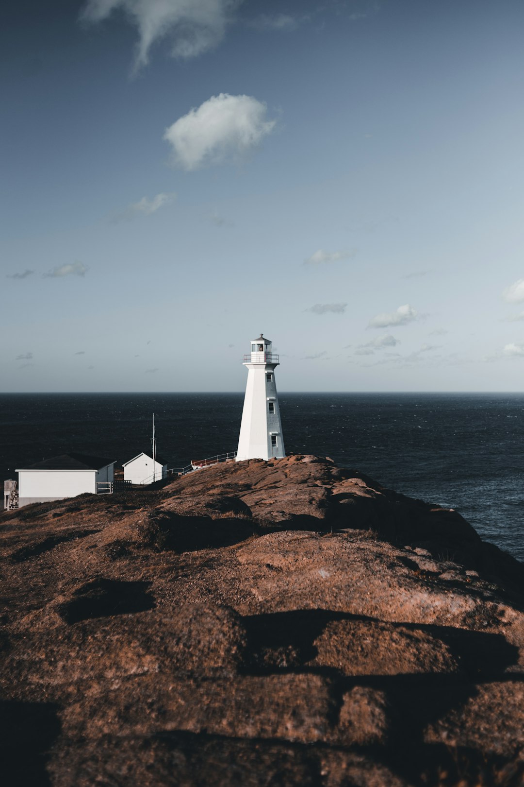 white and brown lighthouse near body of water during daytime