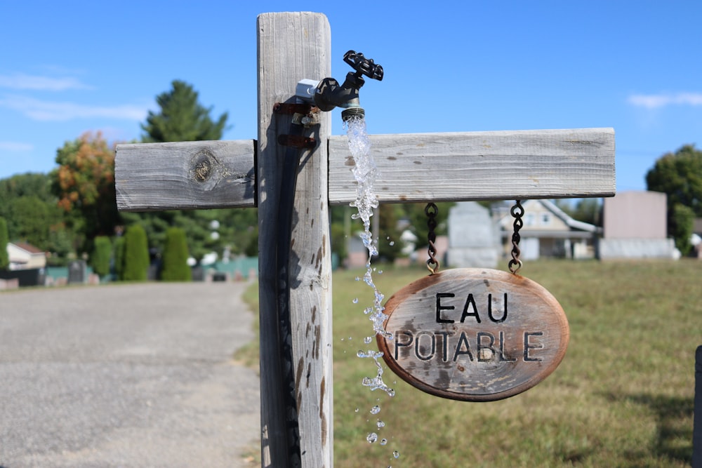 a wooden sign hanging from the side of a wooden fence