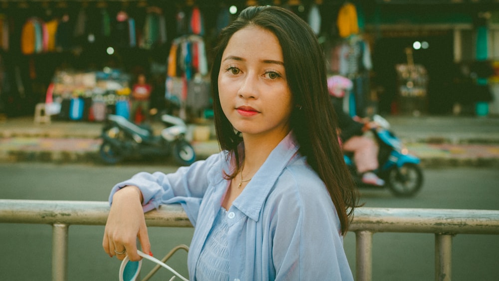 a woman standing next to a metal fence