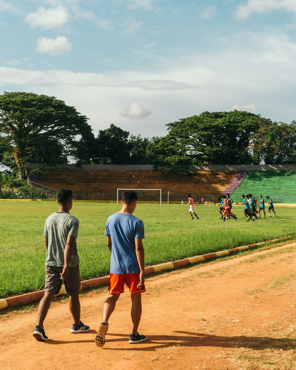 people playing soccer on green grass field near body of water during daytime