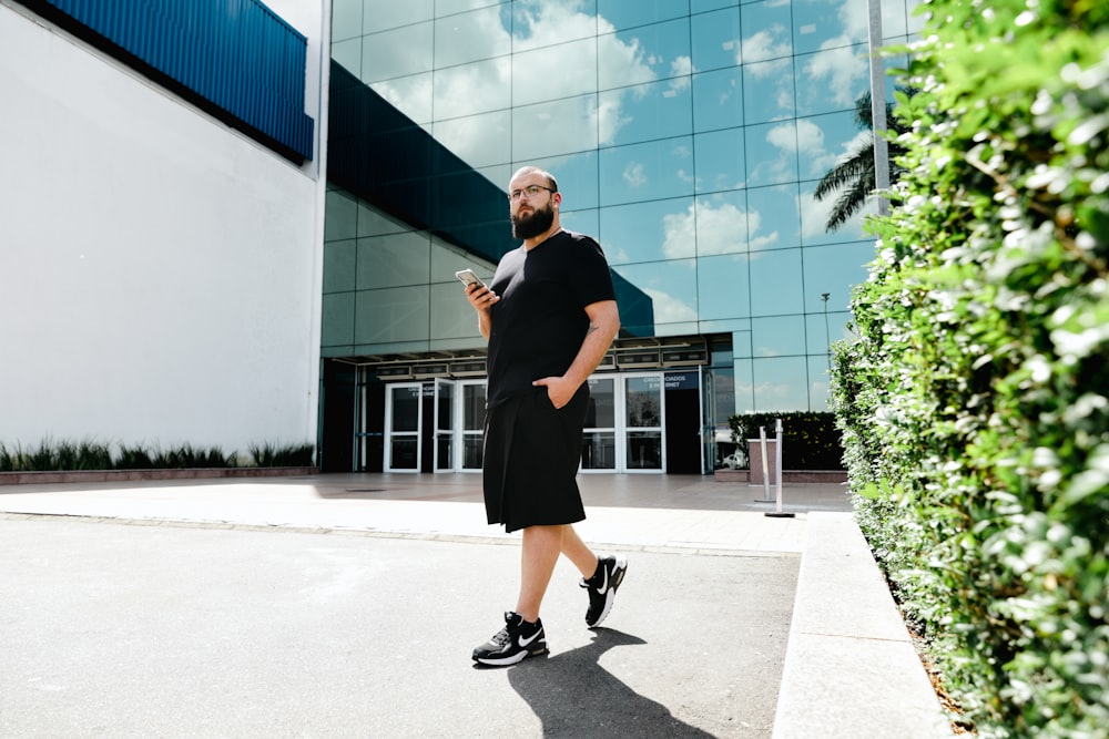 a man with a beard is standing in front of a building