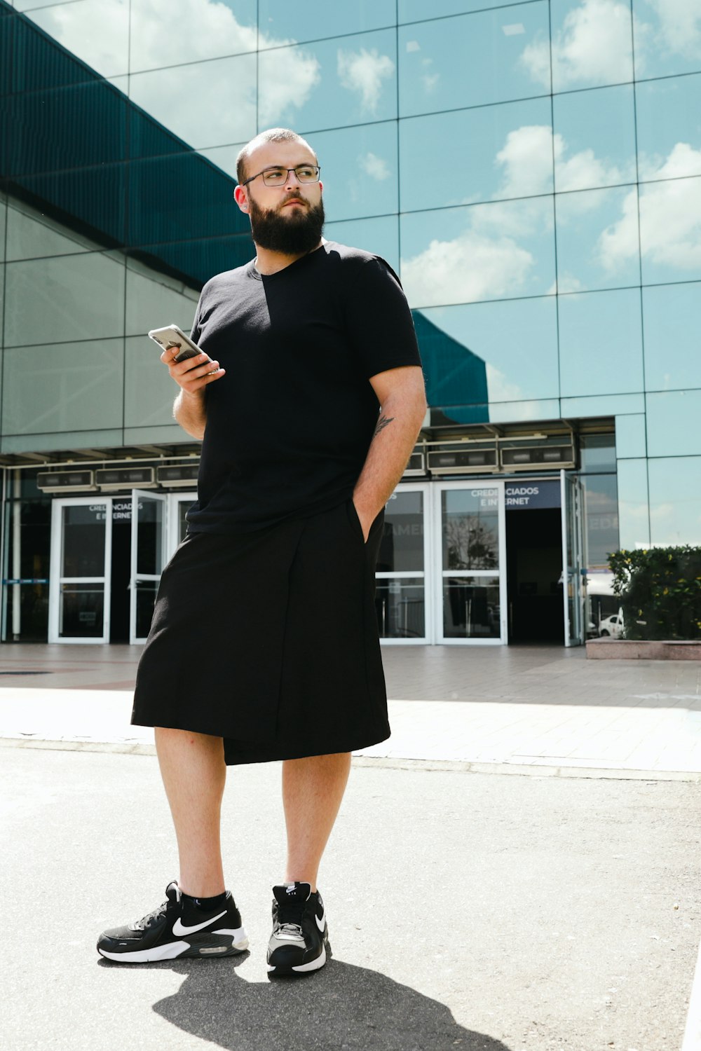 a man standing in front of a building holding a cell phone