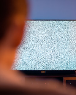 black flat screen tv turned on displaying white screen
