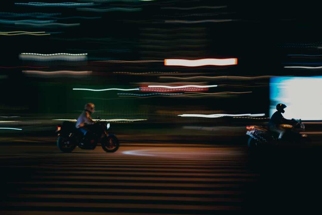 man riding motorcycle on road during night time