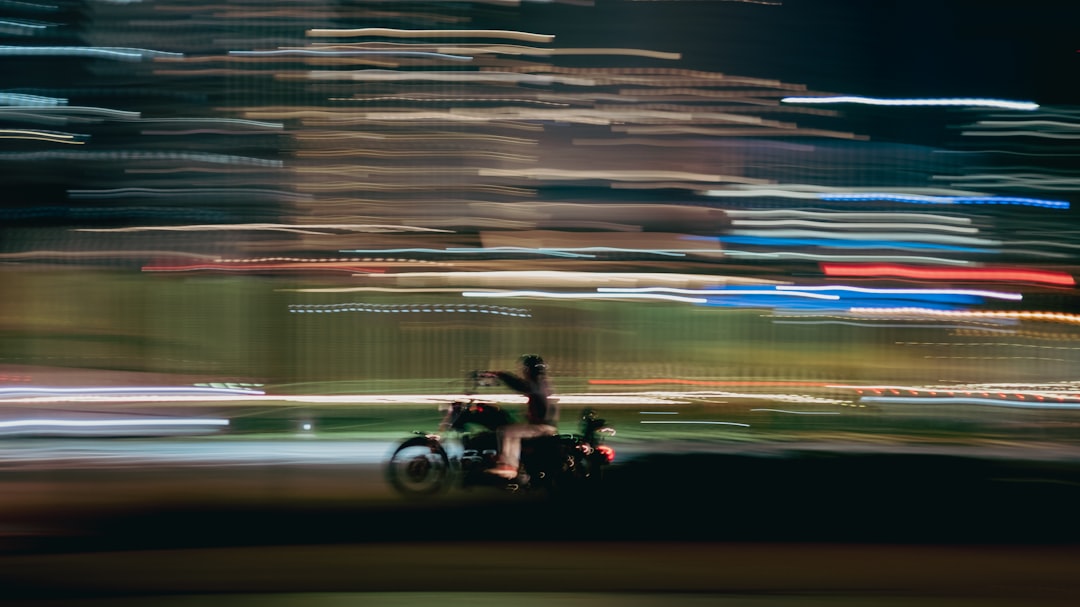 man riding motorcycle on road during night time