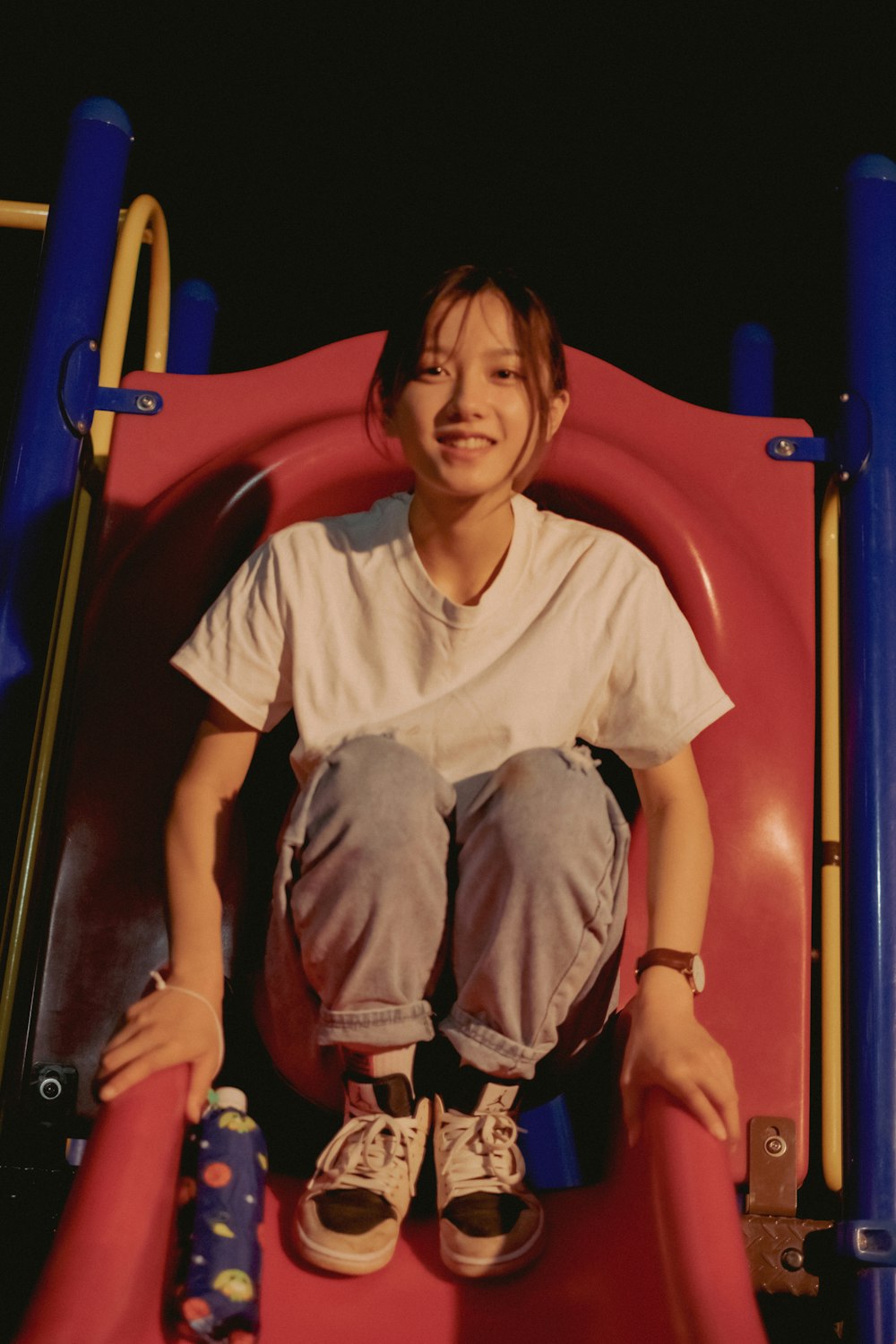 boy in white crew neck t-shirt and blue denim shorts sitting on red and blue