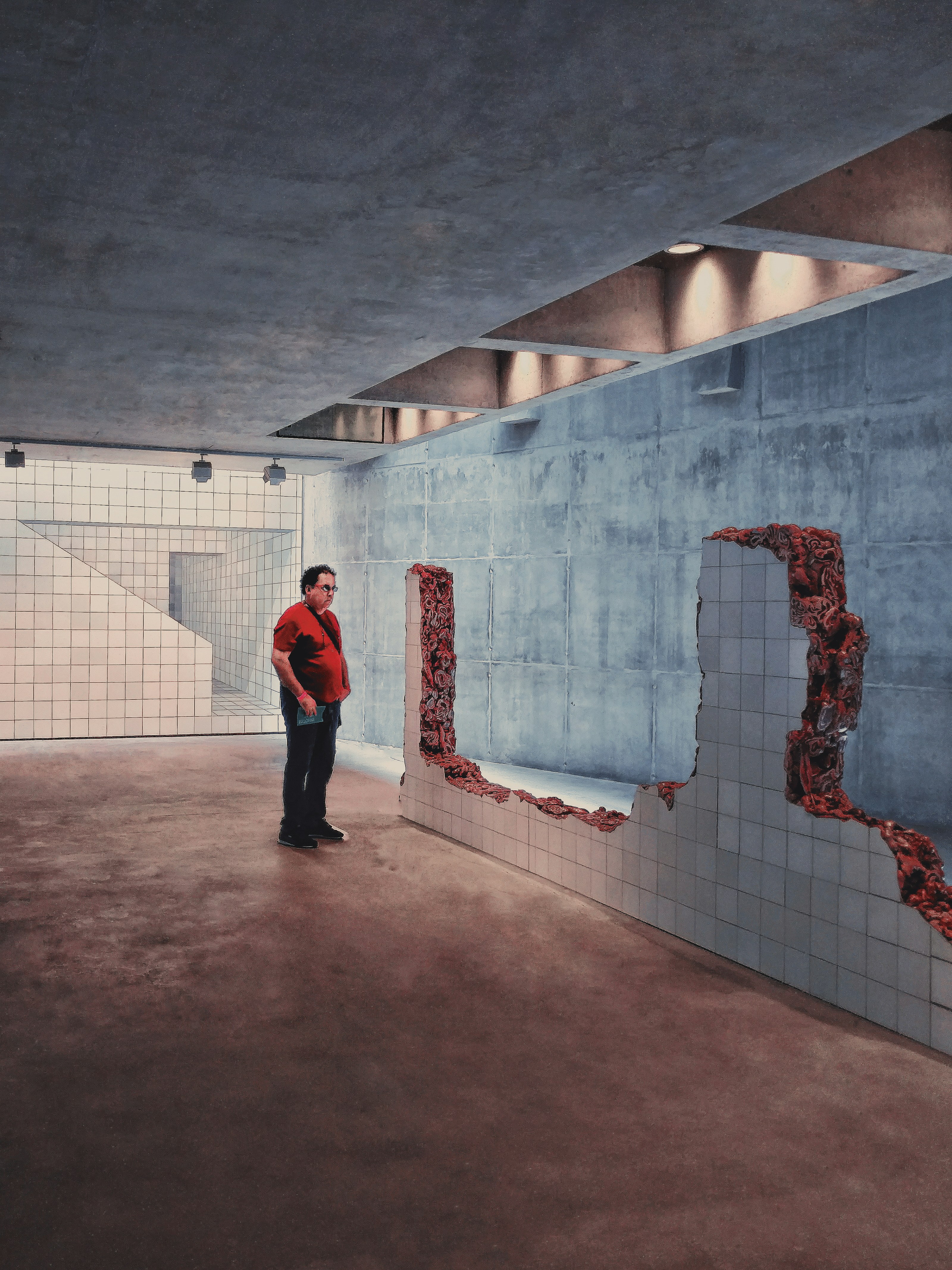 man in red and black jacket standing beside white and red wall