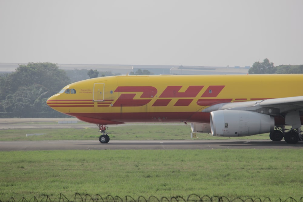 Avión de pasajeros amarillo y rojo en el aeropuerto durante el día