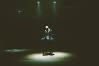 man in black and white plaid dress shirt sitting on chair