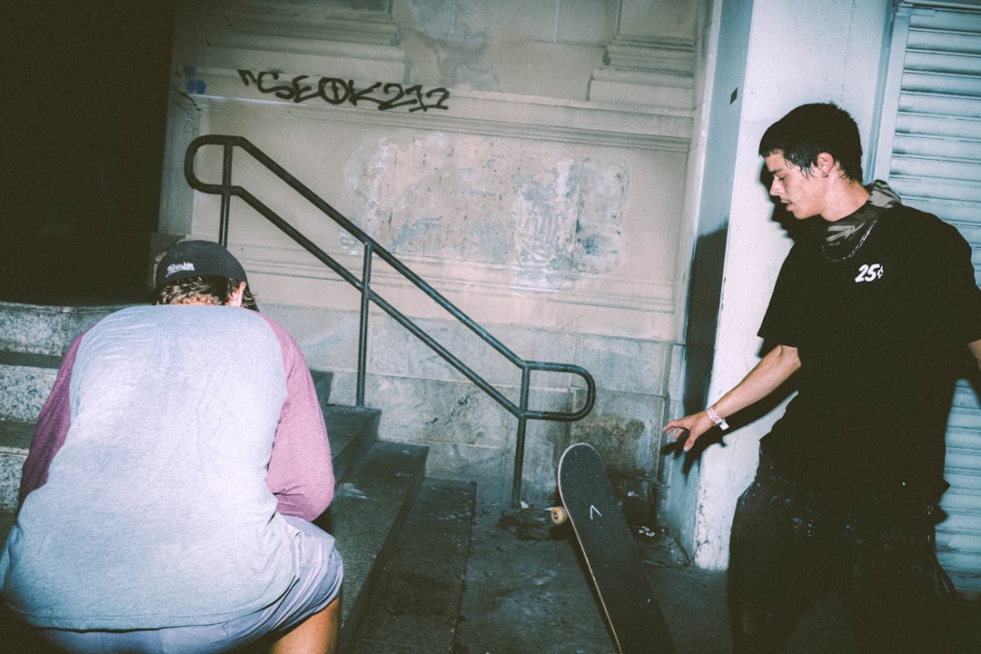 woman in pink shirt and black pants standing on stairs