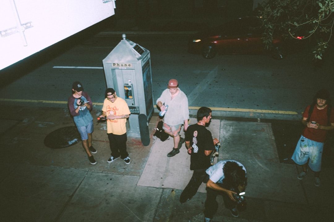 group of people standing on sidewalk during night time