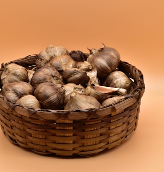 brown and white garlic on brown woven basket