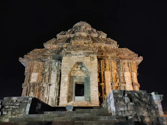 A mystical night scene of a stone temple adorned with intricate prehispanic patterns glowing softly.