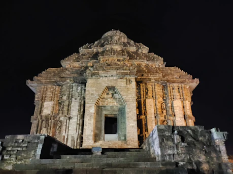 A mysterious ancient stone temple illuminated by turquoise and gold light under a starry obsidian sky.