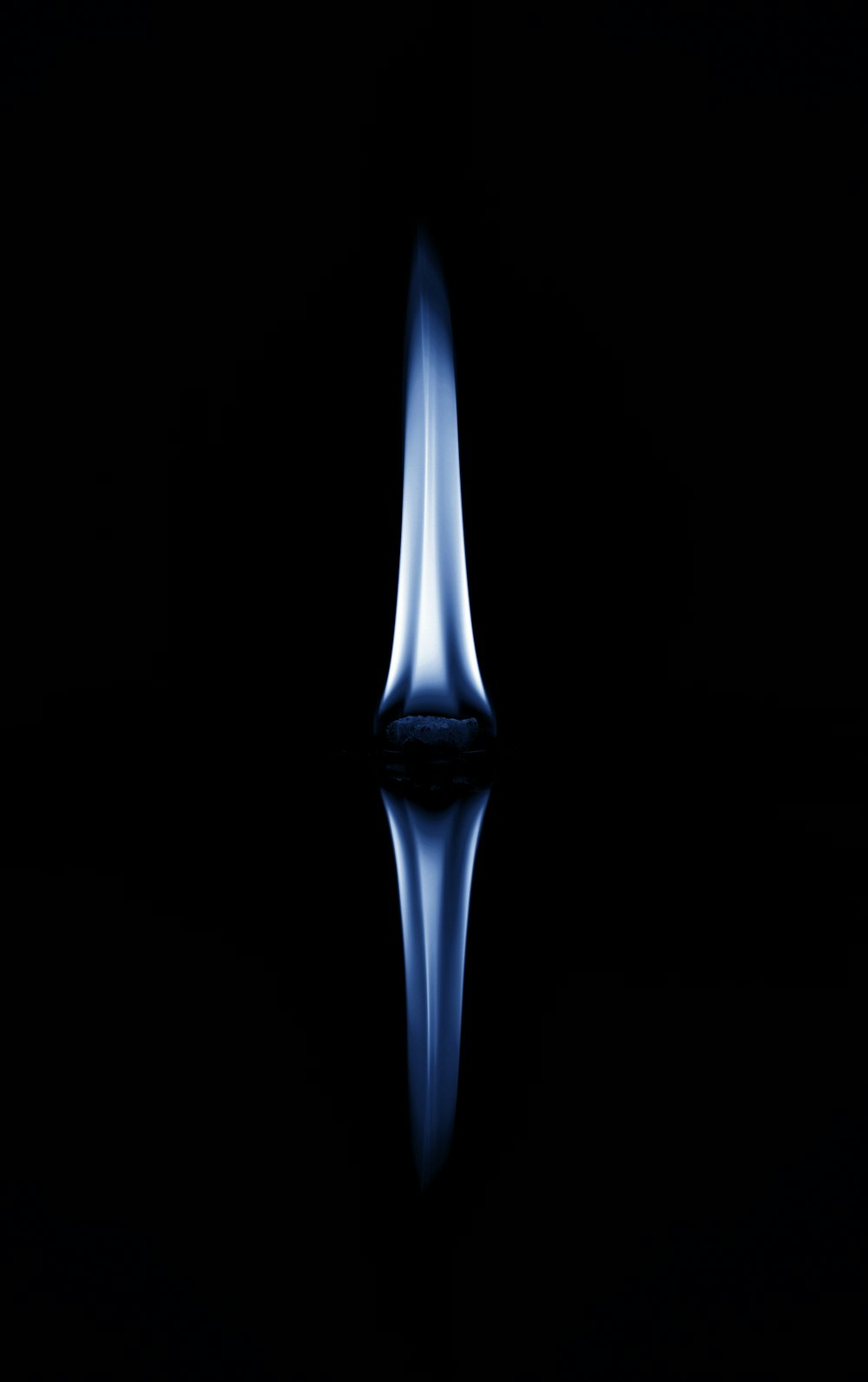a black background with a blue flame in the middle