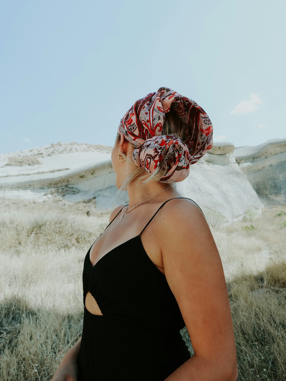 Mujer con camiseta sin mangas negra con hiyab floral rojo y blanco