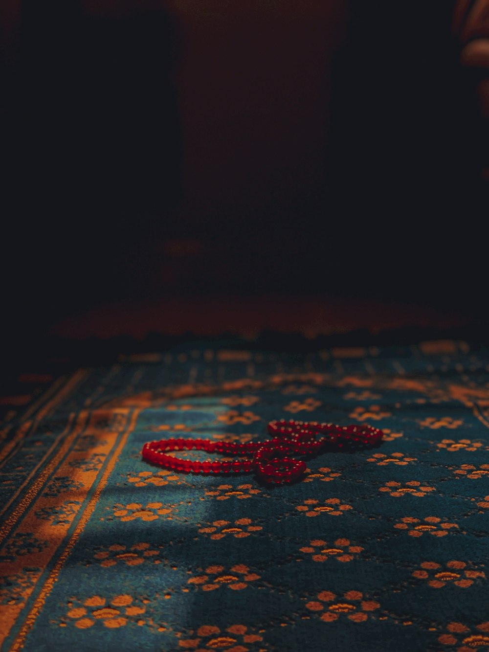 una corda rossa che giace sopra un tappeto blu