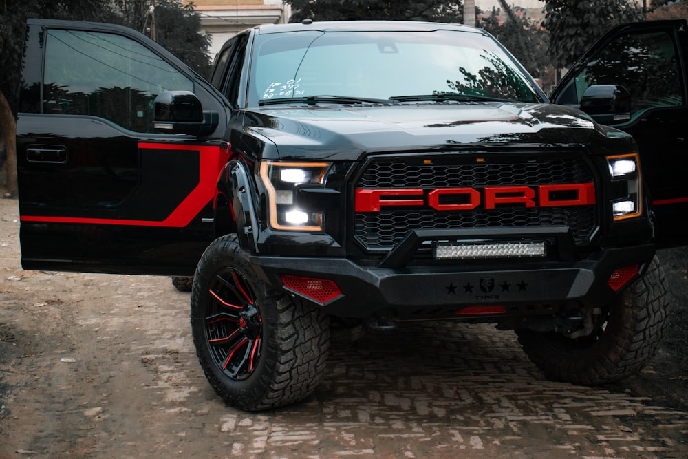 a black and red truck parked next to another black truck