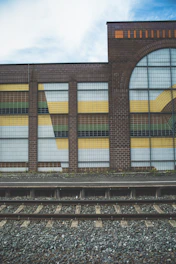 brown and black concrete building under white clouds and blue sky during daytime