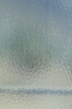 A sleek transparent glass effect contact form interface with blue liberty and cyan gradient background.