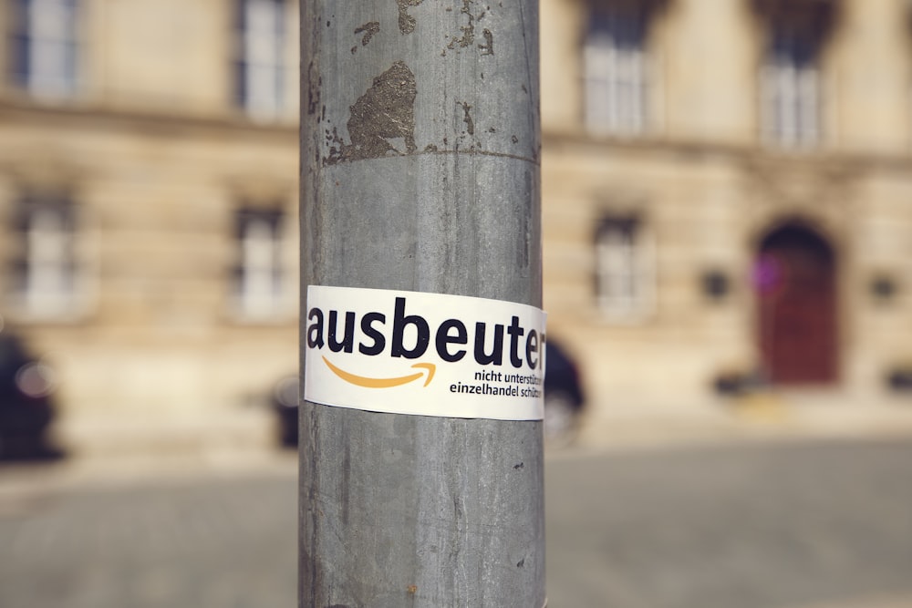 white and yellow sticker on brown wooden post