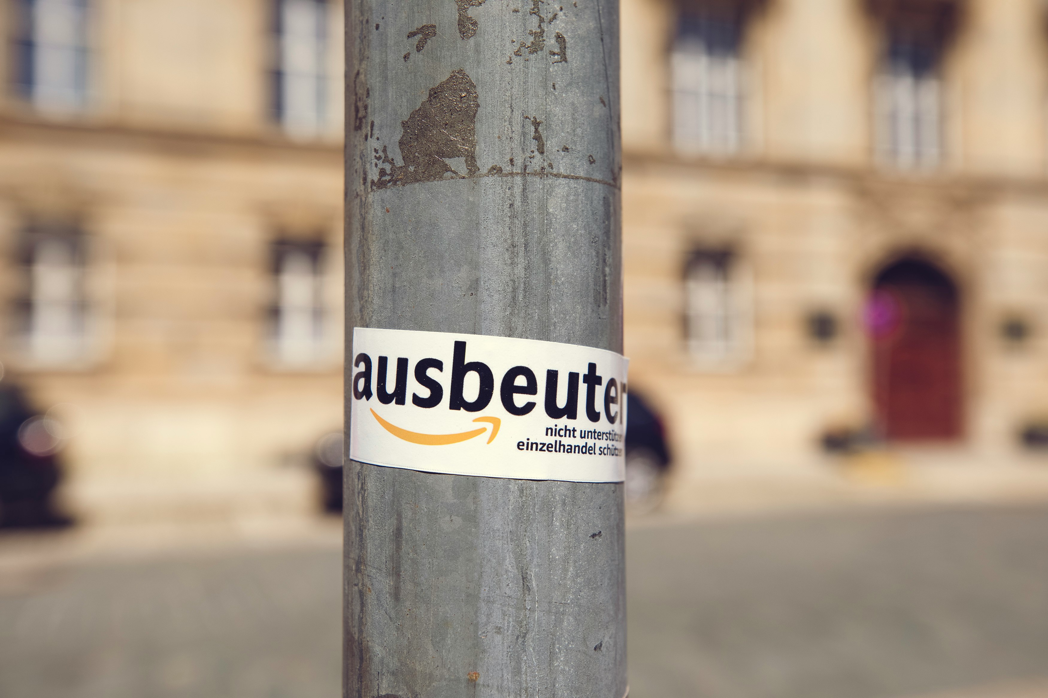 white and yellow sticker on brown wooden post