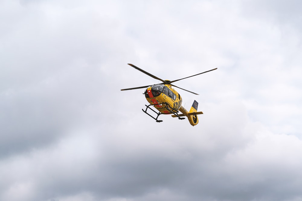 gelb-schwarzer Hubschrauber fliegt am Himmel