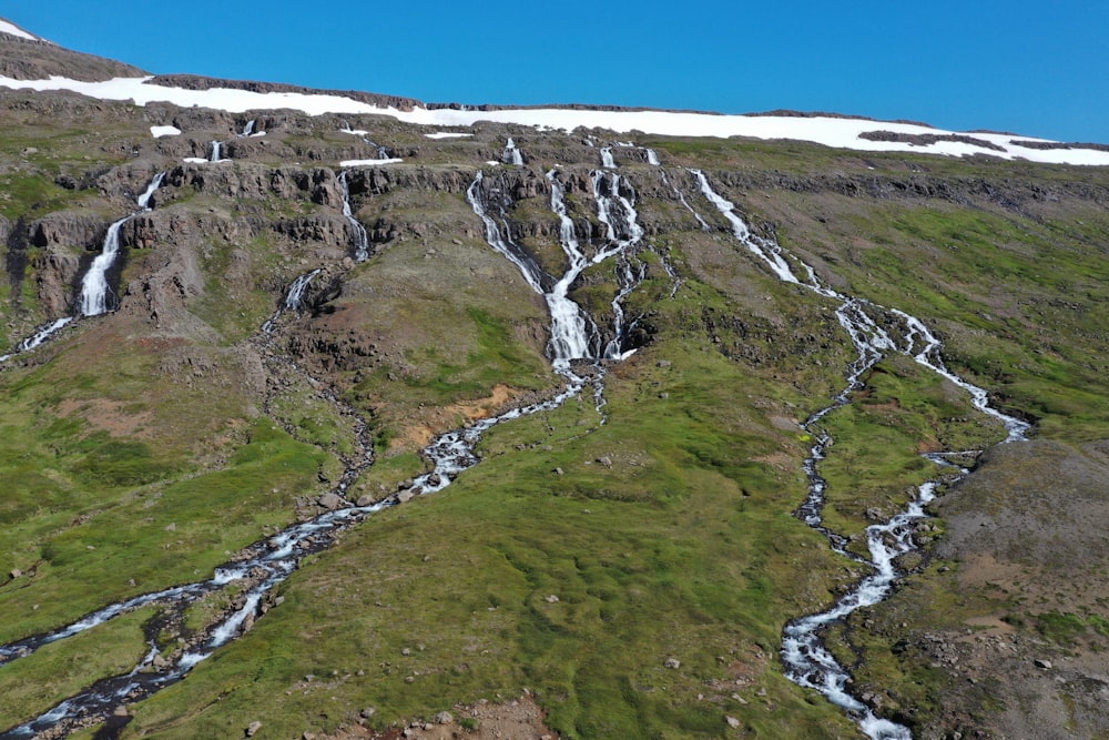 an aerial view of a mountain with a stream running through it