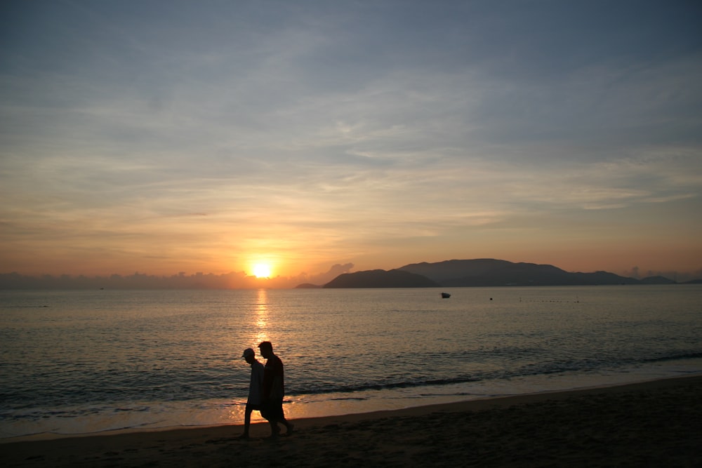 a man standing on top of a beach next to the ocean