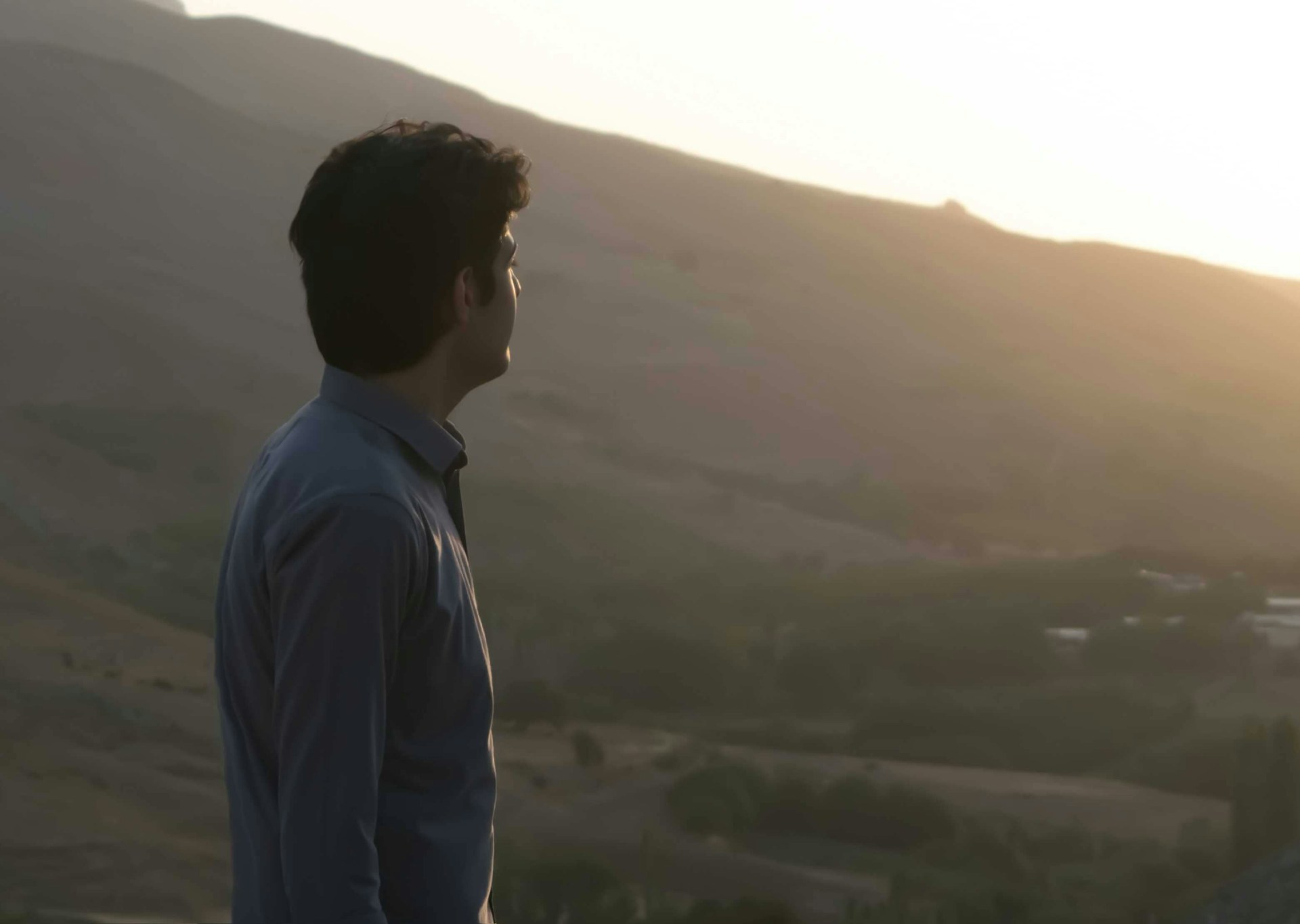 a man standing on top of a lush green hillside