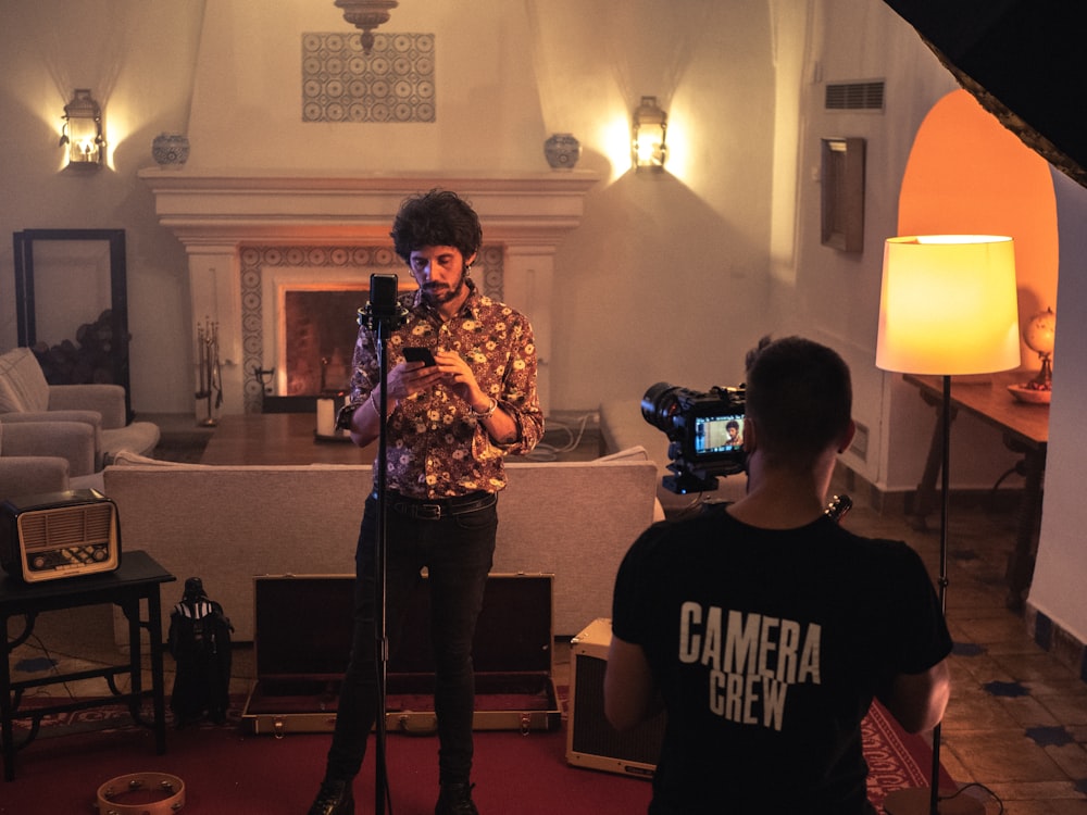a man standing in a living room holding a camera