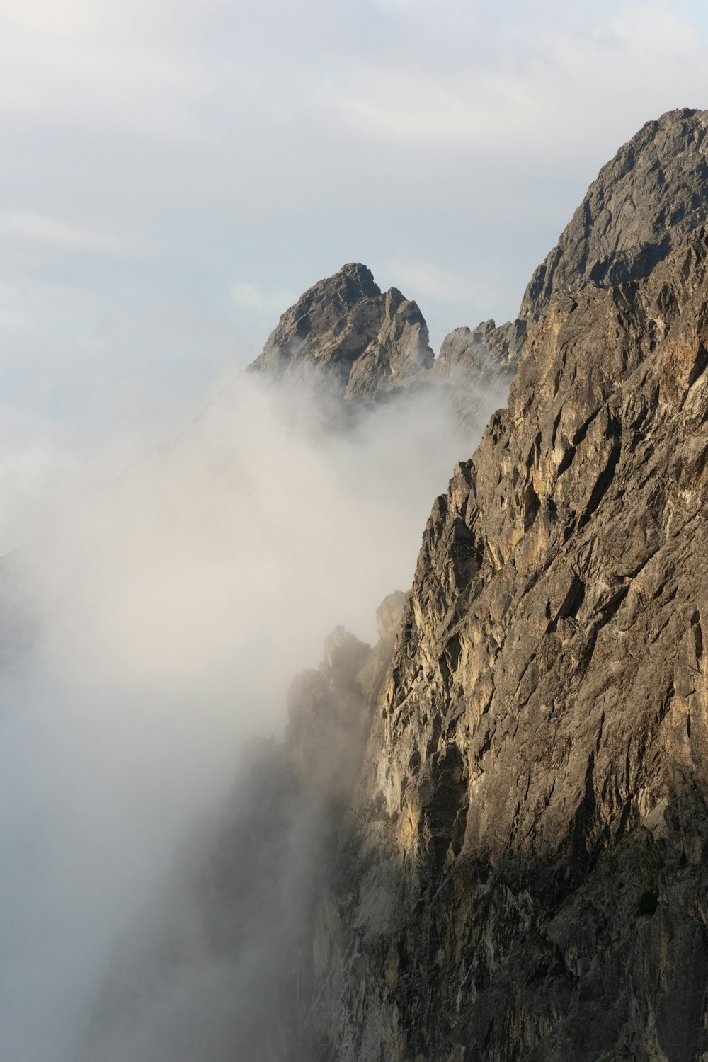 a very tall mountain with some clouds in the air